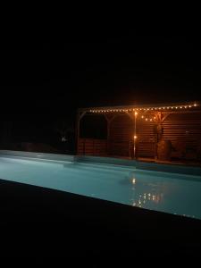 a swimming pool at night with lights around it at Las Mijeannos in Cazalrenoux