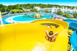 a boy sliding down a slide at a water park at Appartamenti Bellaria Vacanza e Relax in Bellaria-Igea Marina