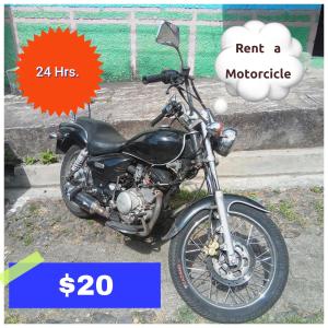 a black motorcycle parked on the side of a street at Accomodation Hostal El Pacifico in Juayúa