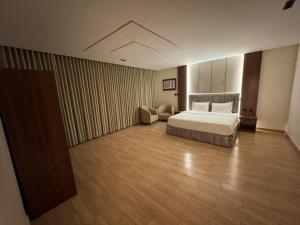 a bedroom with a bed and a chair in a room at ارام للشقق المخدومة in Taif