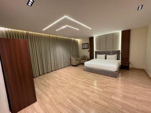 a bedroom with a bed and a chair in a room at ارام للشقق المخدومة in Taif +6 photos
