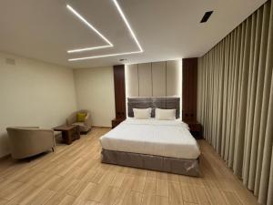 a bedroom with a bed in a room with curtains at ارام للشقق المخدومة in Taif