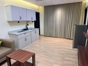 a kitchen and living room with a couch and a table at ارام للشقق المخدومة in Taif