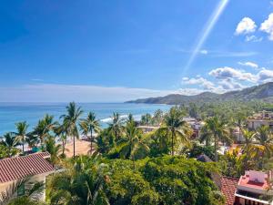 a view of a beach with palm trees and the ocean at Nomada Wellness Hotel in Sayulita