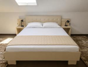 a large bed in a room with two night stands at Vila Rin in Mangalia
