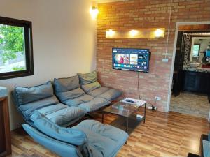a living room with a couch and a tv at Koh Tao Studios 47 in Ko Tao