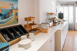 a kitchen with a counter with white dishes on it at Narkissos Hotel in Kamari