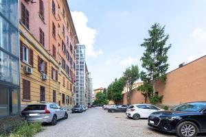 a row of cars parked on a street next to buildings at Moon Bologna in Bologna