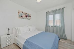 a white bedroom with a bed and a window at House Green in Vrh +23 photos