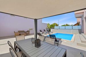 a patio with a table and chairs and a swimming pool at House Green in Vrh