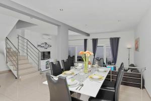 a dining room with a white table and chairs at House Green in Vrh