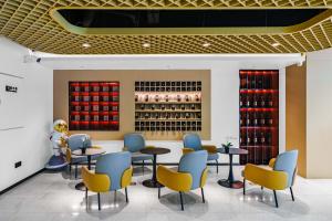 a restaurant with tables and chairs and wine bottles at NOX Hotel in Chengdu +48 photos