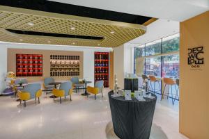 a restaurant with tables and chairs and wine bottles at NOX Hotel in Chengdu