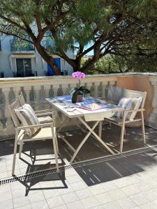 a picnic table with two chairs and a flower on it at Residence Suite Smeraldo in Riccione