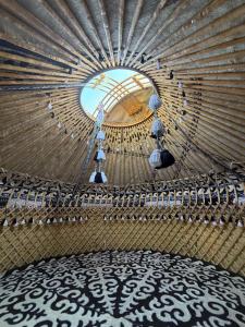 a large room with a ceiling with a mirror at Yurt guesthouse in Osh