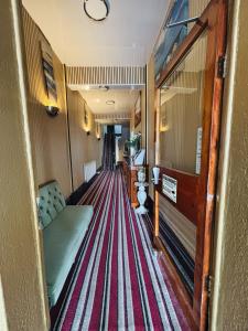 a hallway with a couch and a striped carpet at The Jack Sparrow Hotel in Blackpool +39 photos