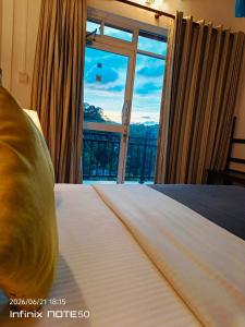 a bedroom with a bed with a large window at Jaye's Homestay in Kandy