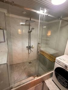 a shower with a glass door in a bathroom at Yurt guesthouse in Osh