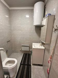 a small bathroom with a toilet and a sink at Yurt guesthouse in Osh