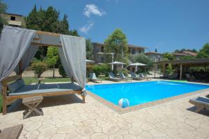 a swimming pool with lounge chairs next to a house at Ilias Apartments in Ipsos