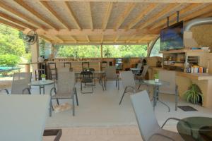 a restaurant with tables and chairs and a patio at Ilias Apartments in Ipsos
