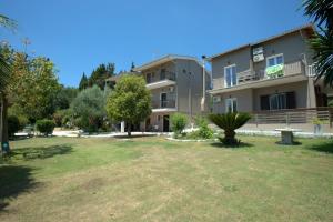 an apartment building with a yard in front of it at Ilias Apartments in Ipsos