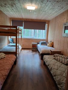 a room with three bunk beds and a window at Männi puhkebaas in Karjamaa