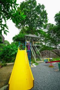 a playground with a yellow slide in a park at Rock Haven Wayanad Resort and Experiences in Kalpetta