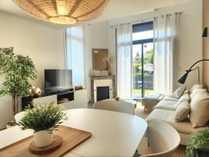 a living room with a couch and a table at La villa d'Alix avec jardin et parking in Bègles