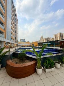a building with a swimming pool and some plants at Sofitel Caravanserai 1BHK Noida, Spectrum Mall Sector 75 in Noida