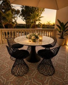 a table and chairs on a patio with the sunset at Tenuta Legaro in Cozzana