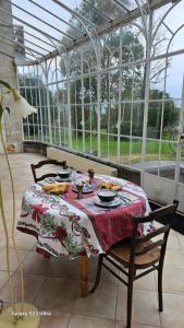 a table in a conservatory with a table cloth on it at Chambre Napoléon III in Fleuriel