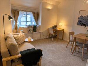 a living room with a couch and a table at Historic High St Flat with Peaceful Garden Retreat in Stony Stratford