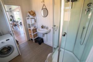a bathroom with a sink and a washing machine at Skandi Design Ferienhaus mit Hafenblick & Beach in Wandlitz +28 photos