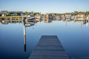 a dock in the water with boats and houses at Skandi Design Ferienhaus mit Hafenblick & Beach in Wandlitz