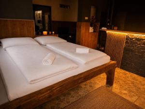 a large bed with white sheets and towels on it at Wellness Glamping Apartmán Přerov in Přerov