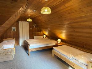 a bedroom with two beds in a wooden ceiling at Chalupa Jaseň in Ždiar
