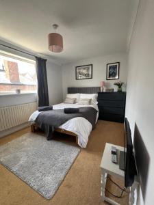 a bedroom with a bed and a tv in it at Beach House Manningtree in Manningtree