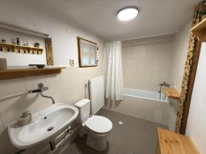 a bathroom with a sink and a toilet and a tub at Chalupa Jaseň in Ždiar