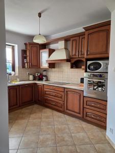 a large kitchen with wooden cabinets and appliances at Agroturystyka u Kasi in Suryty +12 photos