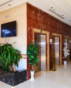 a lobby with a wall with a television and plants at Vivian AL Shasha in Mecca