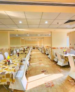 a banquet hall with long tables and white chairs at Vivian AL Shasha in Mecca