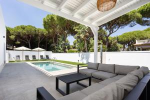 a patio with a couch and a table next to a pool at Fely Sea Villa in Novo Sancti Petri