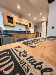 a kitchen with a wooden table with a sign on it at Villa du Parc le Lilas in Formiguères