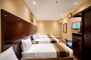 a hotel room with two beds and a tv at الارض المتميزة -1 - نبراس الهدى - Nebras ElHoda in Mecca