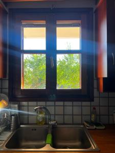 a kitchen sink with two windows above it at Almyra Seaside Apartments in Elia Laconias +42 photos