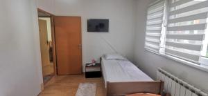 a small room with a bed and a window at 2 BDR Family Apartment In Sarajevo - Free Parking in Sarajevo