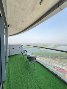 two chairs and a table on a balcony with a view at Luxurystay-supernova in New Delhi +4 photos