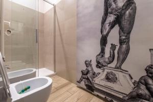 a bathroom with a statue of a man on the wall at Sun Bologna in Bologna +80 photos