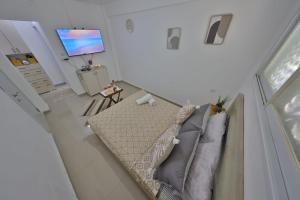 a living room with a couch and a flat screen tv at אירוח סמוך לים התיכון יש מקלט בבניין in Haifa